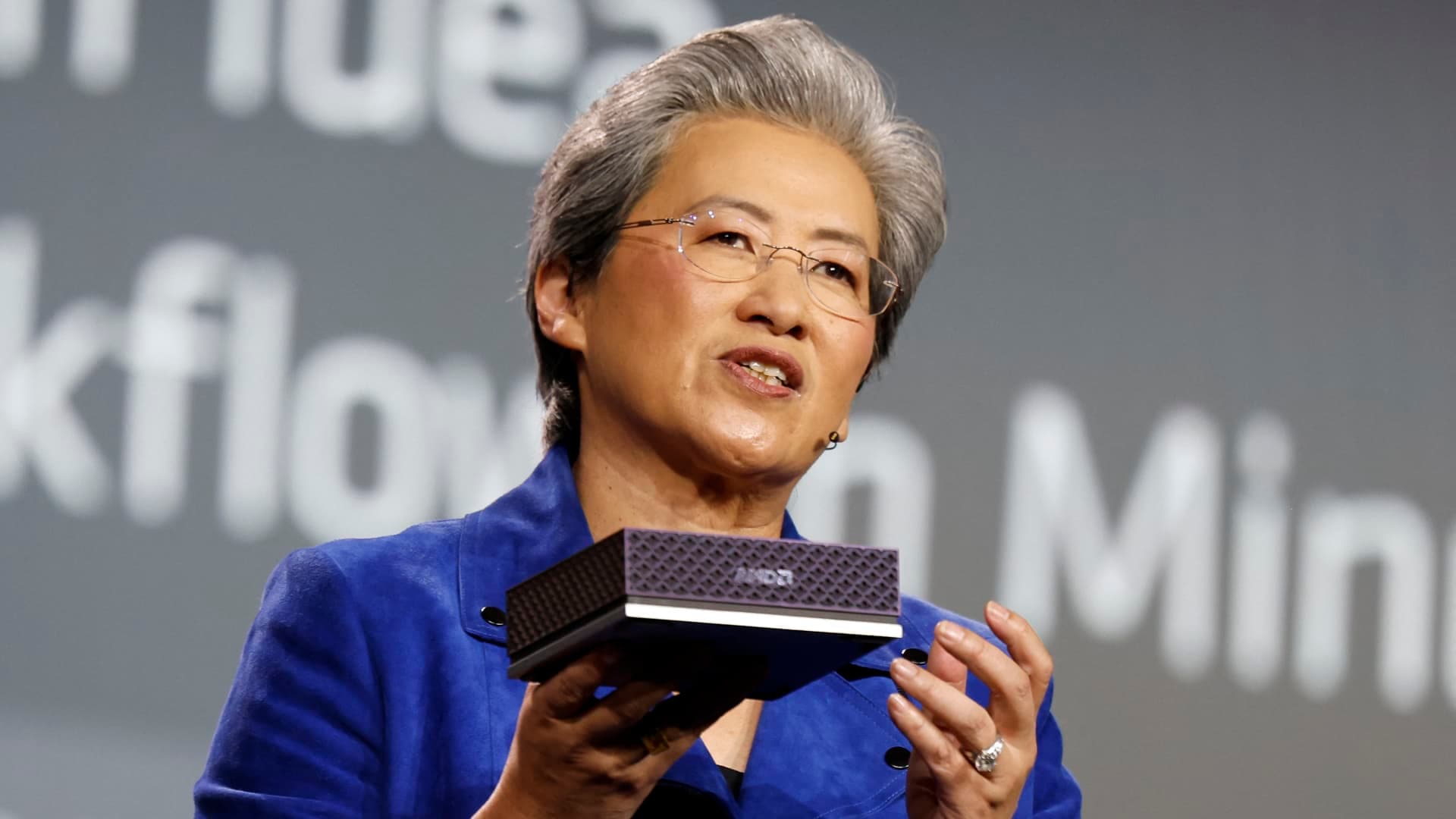 AMD CEO Lisa Su holding an AMD Instinct AI accelerator during a product presentation