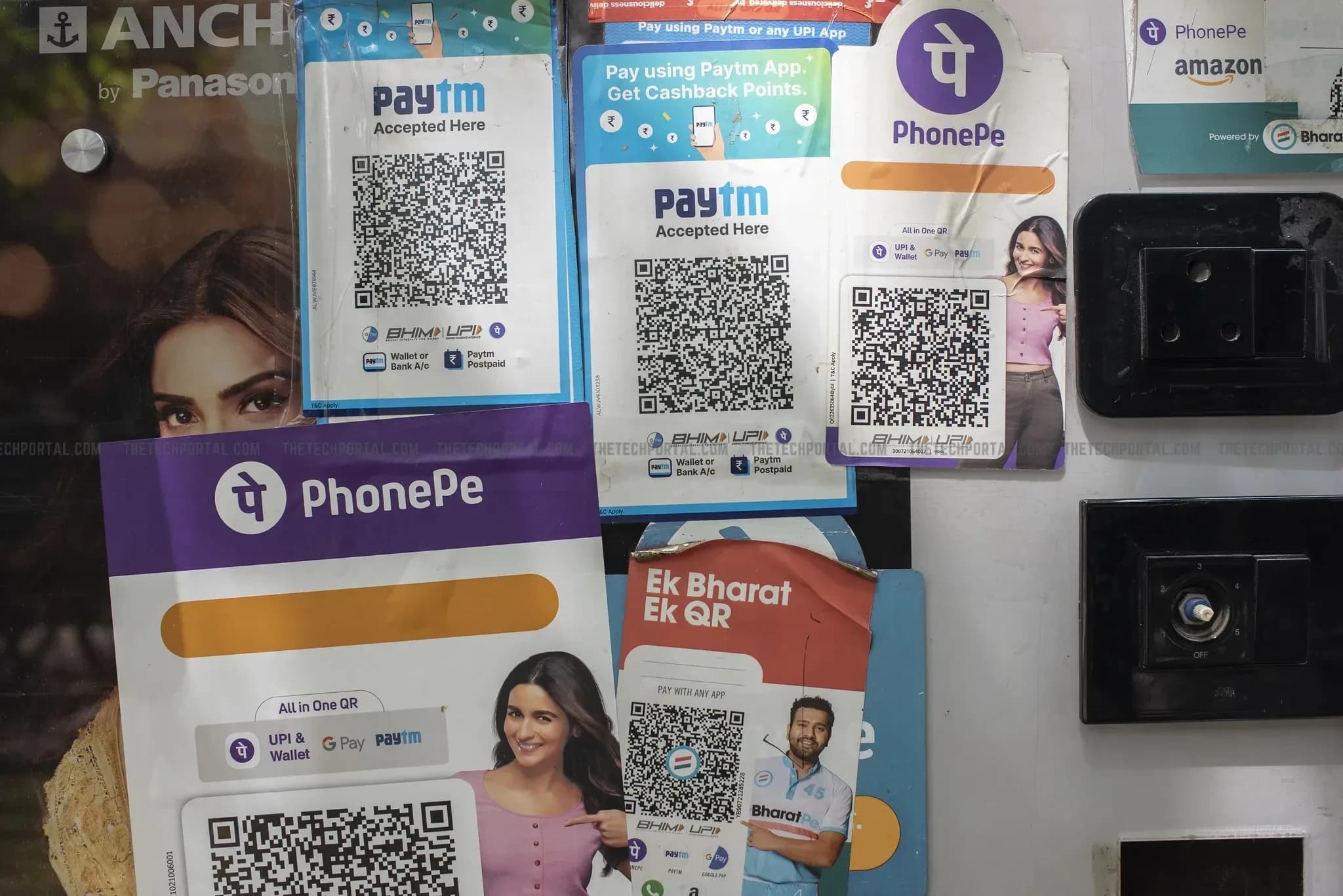 A Zimbabwe Gold banknote alongside UPI QR code payment stickers at a market stall, illustrating a link between Africa's retail economy and India's payments network